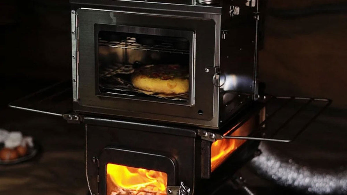 Kaminprodukte, Holzofen mit brennendem Feuer unter einem Backfach mit Brot hinter Glas