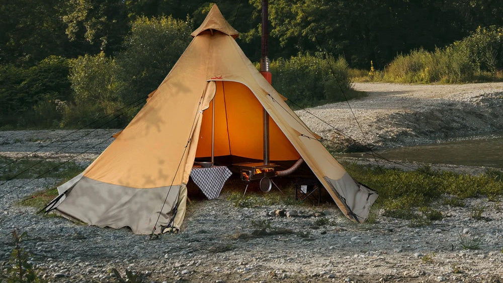 Öfen, Tipi Zelt mit offener Tür und warmem Licht im Inneren auf einer Kiesfläche am Wasser