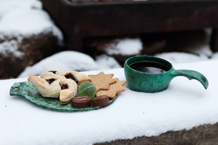Grüner Kupilka 14 Small Teller mit Keksen im Schnee neben einem grünen Becher mit Tee