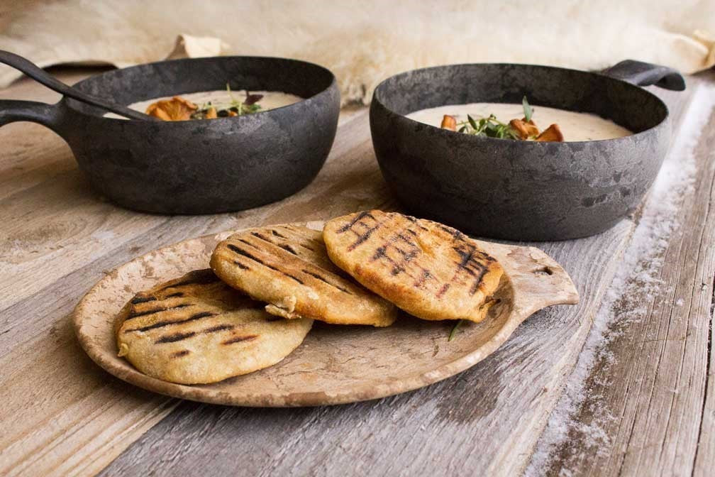 Kupilka 14 Small Teller in Braun mit gegrillten Sandwiches auf einem Holztisch neben Töpfen mit Suppe