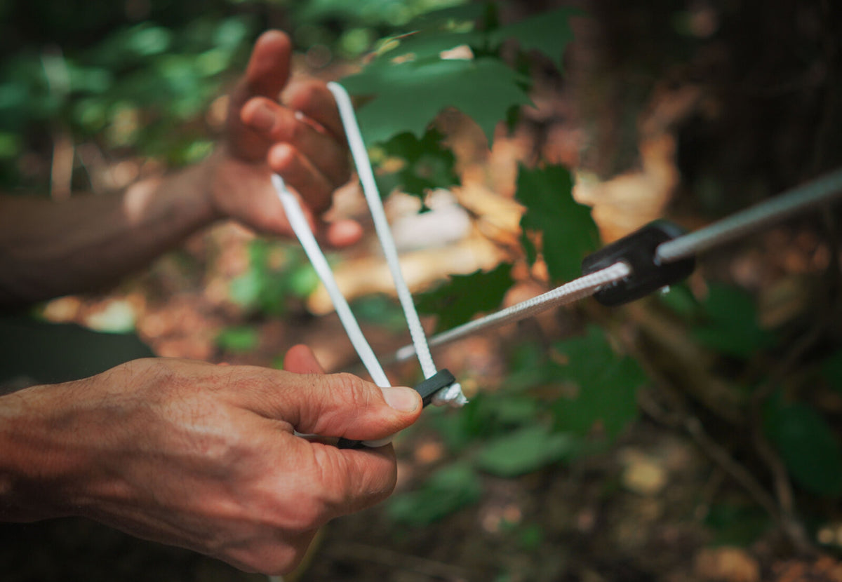 CanvasCamp Abspannleine mit Spanner, im Wald in der Hand gehalten