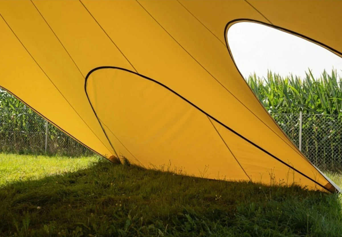 CanvasCamp StarShade Pro geschlossene Seitenwand in Gelb, von innen gesehen neben einem Maisfeld