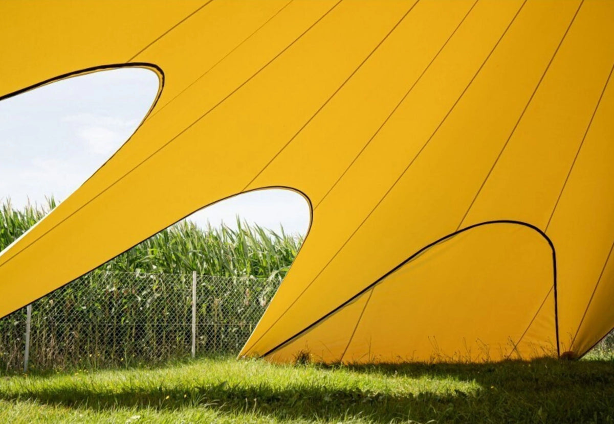CanvasCamp StarShade Pro geschlossene Seitenwand in Gelb mit geschwungenen Öffnungen und Blick auf Mais