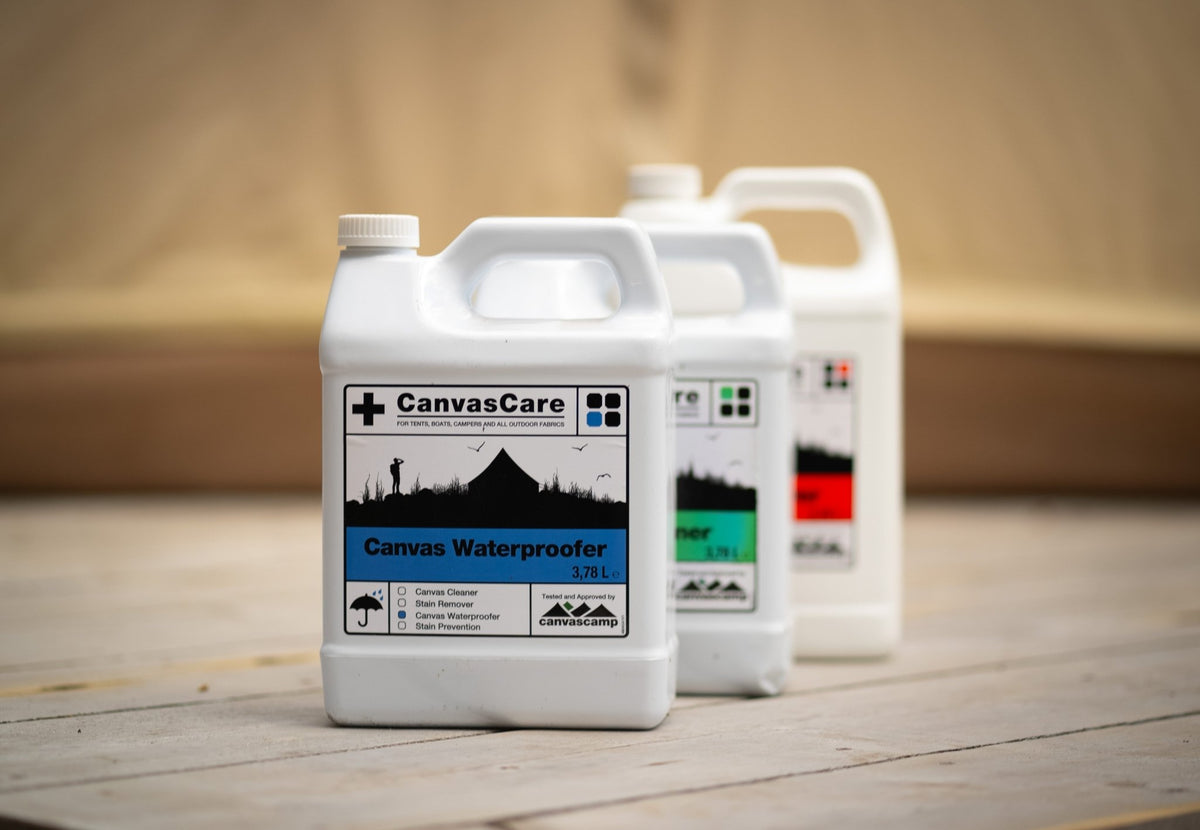 CanvasCare Waterproofer vorne auf einem Holzdeck, neben Kanistern mit grünem und rotem Etikett