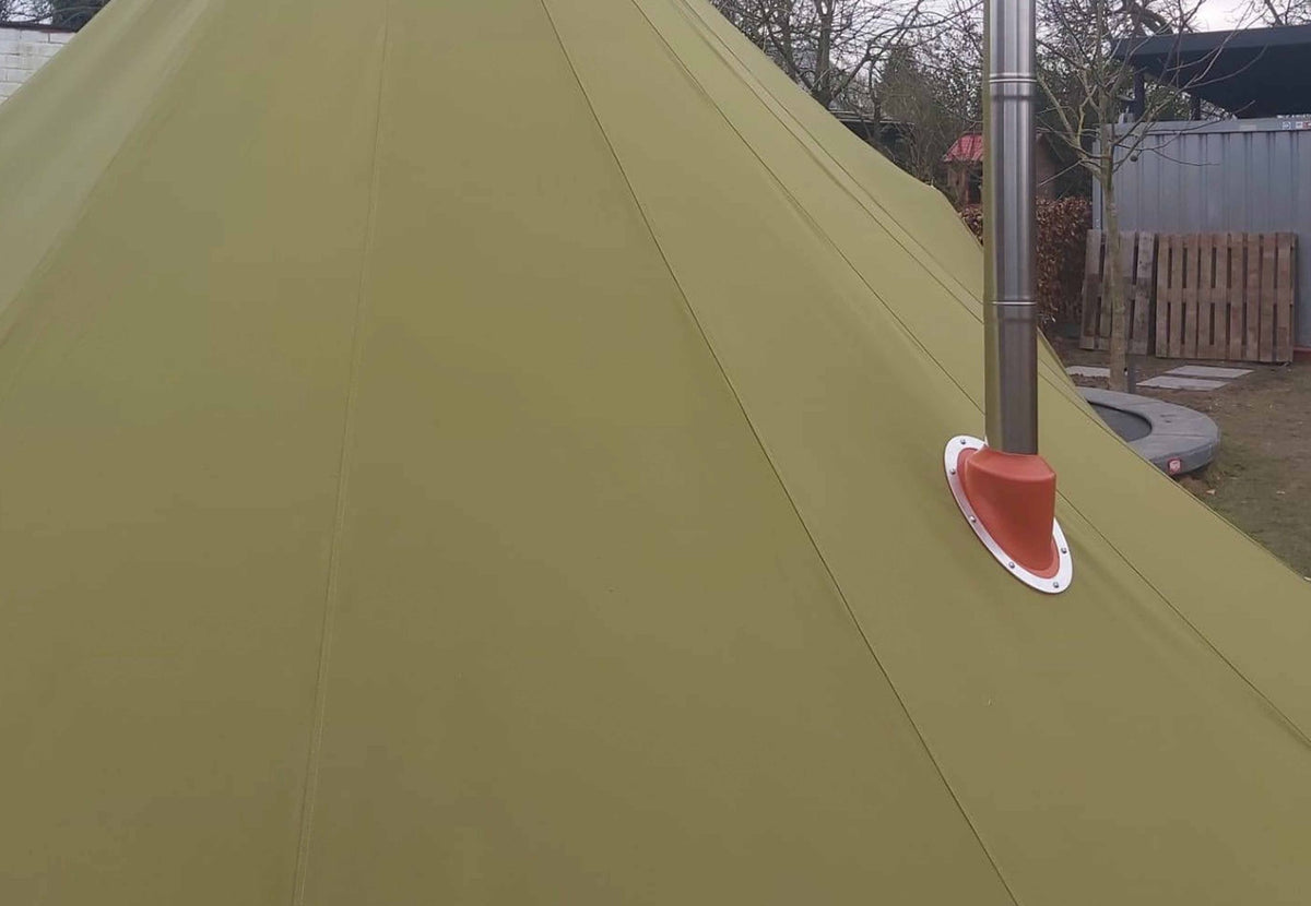 CanvasCamp Exit 45° auf grünem Zeltstoff mit einem Ofenrohr aus Stahl, Zelt in einem Garten