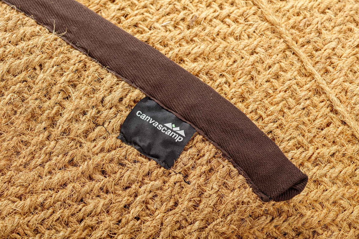 CanvasCamp halbrunde Kokosmatte, brauner Saum mit CanvasCamp Etikett aus der Nähe