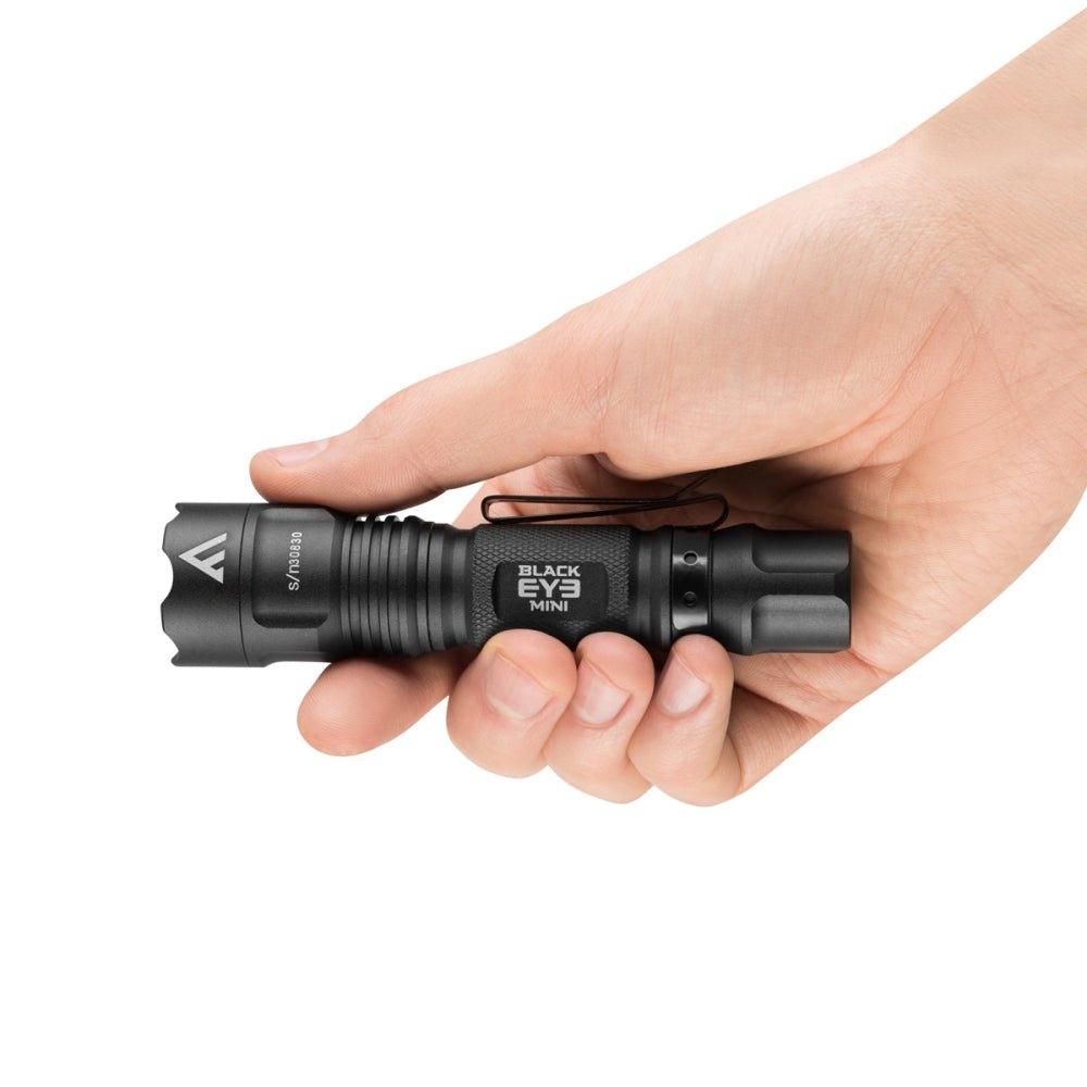 Mactronic Black Eye Mini, kompakte schwarze Taschenlampe in einer Hand, mit Aufdruck auf dem Gehäuse