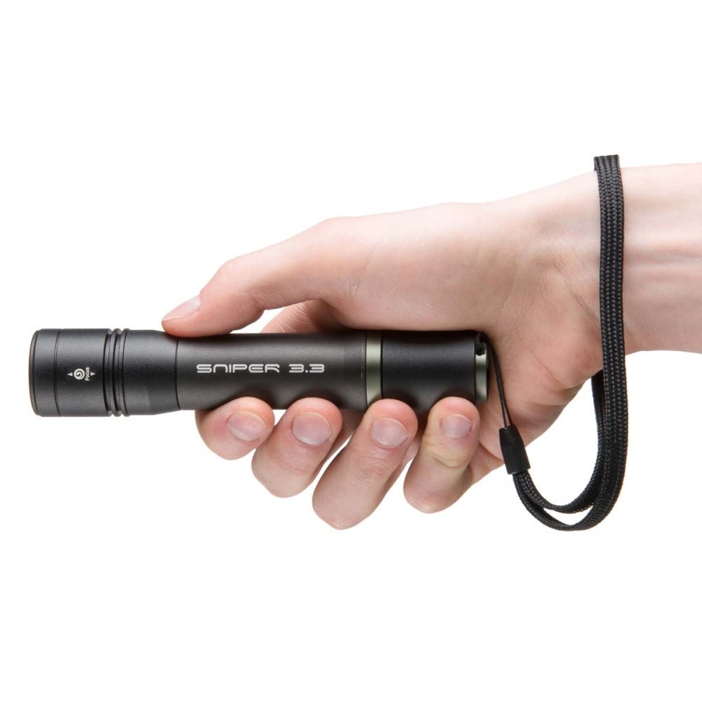Mactronic Sniper 3.3 Taschenlampe in der Hand gehalten mit der Handschlaufe um das Handgelenk