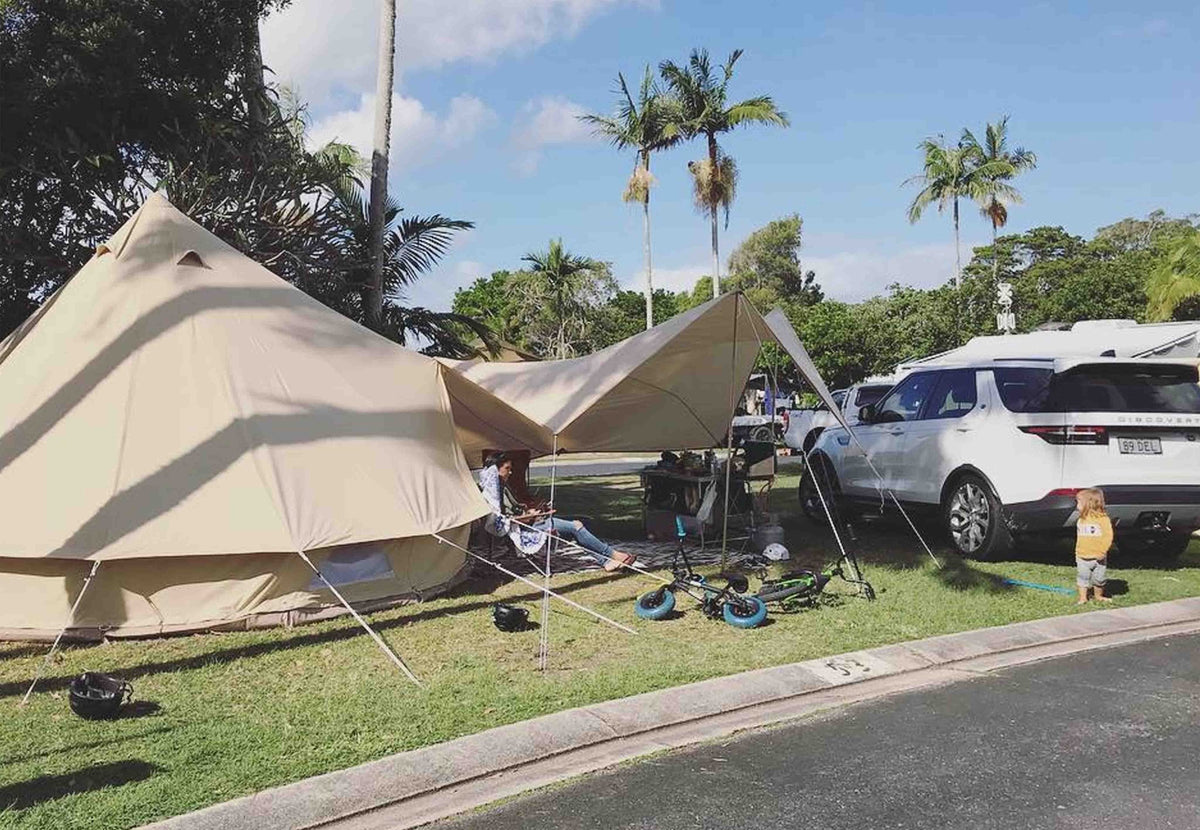 CanvasCamp Malu Vordach an einem Glockenzelt auf einem Campingplatz mit Palmen