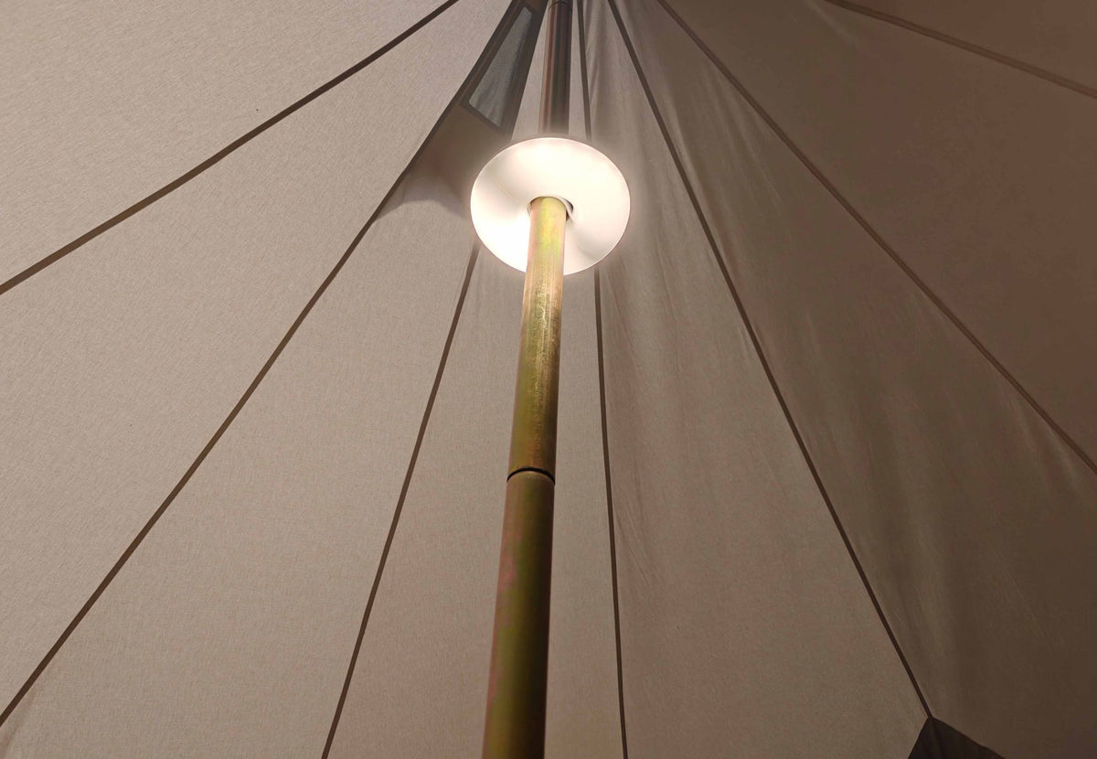 CanvasCamp Aufladbare Zeltbeleuchtung leuchtet rund um die Mittelstange eines Zelts