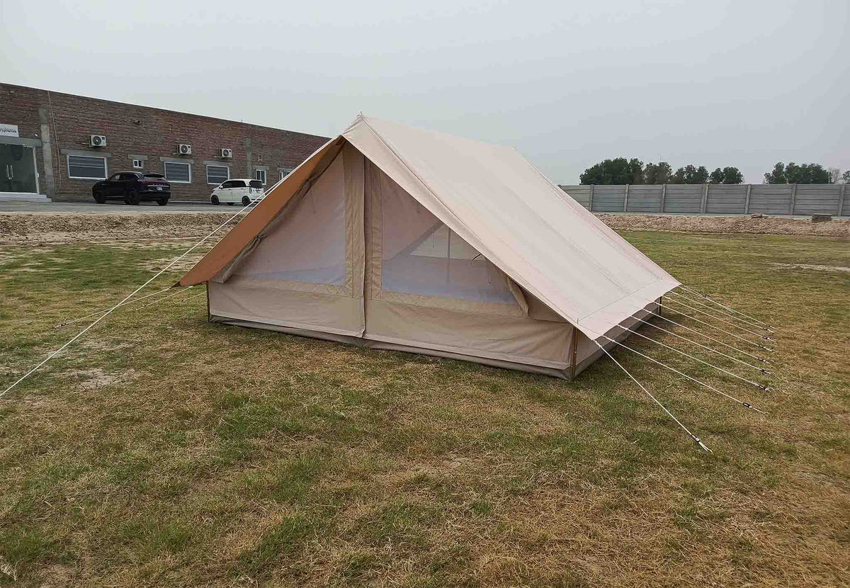 CanvasCamp Patrol Traveller auf einer Wiese aufgebaut, schräg von vorn gesehen