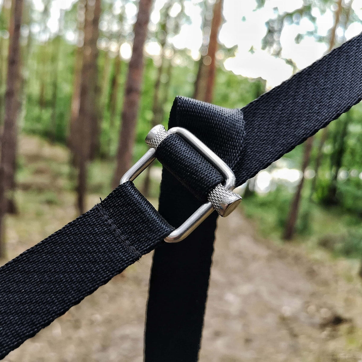 Triplander Quick Drag Metallschnalle mit schwarzem Gurt aus der Nähe in einem Wald