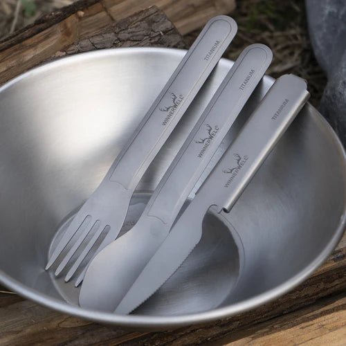 Winnerwell Titanium Cutlery Set in einer Metallschale auf einem Holzklotz im Freien