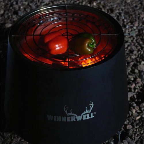 Winnerwell Tornado Fire Pit im Dunkeln mit Paprika auf dem Rost über dem Feuer