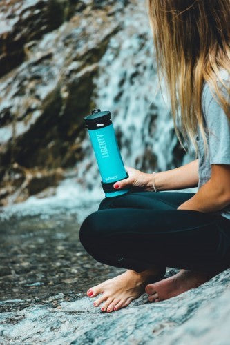 Lifesaver Liberty in Hellblau in der Hand einer Frau auf einem Felsen an einem Wasserfall