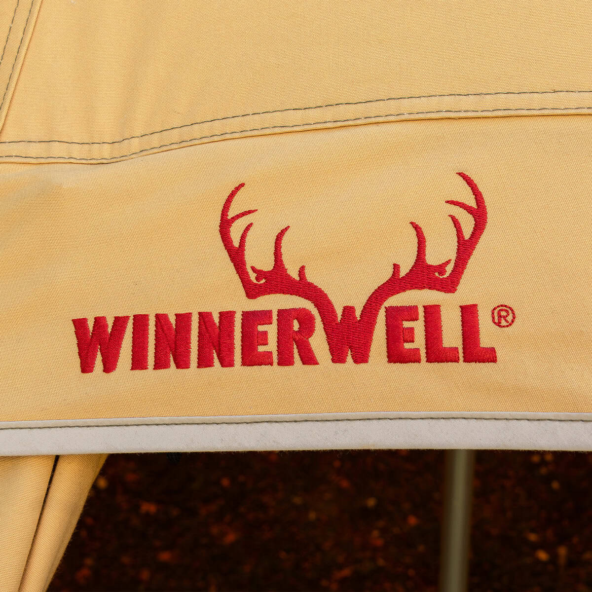 Winnerwell Arctic mit rot gesticktem Winnerwell-Logo mit Geweih auf dem sandfarbenen Stoff