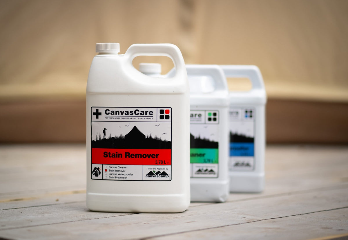 CanvasCare Fleckentferner vorne auf einem Holzboden, dahinter zwei andere CanvasCare Kanister