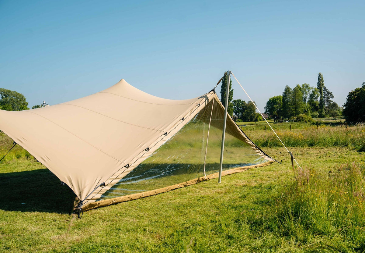 Tür für Stretch Tent an einem beigen Stretchzelt mit Stange und Abspannleinen auf einer Wiese