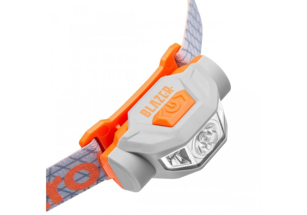 Mactronic Blazer Stirnlampe von der Seite mit dem orangefarbenen Knopf und den Linsen vorne