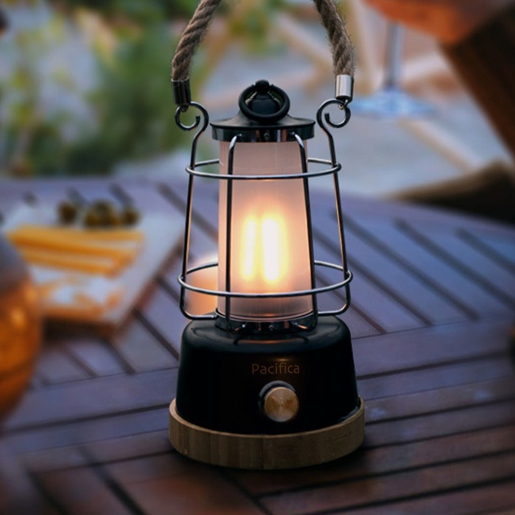 Mactronic Pacifica leuchtend mit warmem Licht auf einem Gartentisch aus Holz im Freien