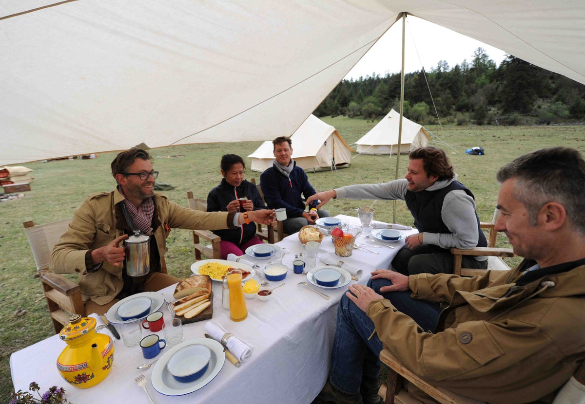 CanvasCamp Malu Vordach über einem gedeckten Frühstückstisch mit Leuten auf dem Campingplatz