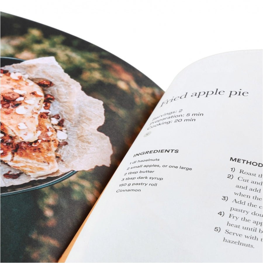 Trangia Moment Kochbuch aufgeschlagen beim Rezept für gebackenen Apfelkuchen