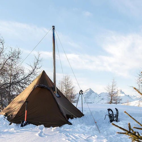 Winnerwell Guyline Peg Set im Einsatz an einem braunen Tipi Zelt im Schnee mit Bergen im Hintergrund