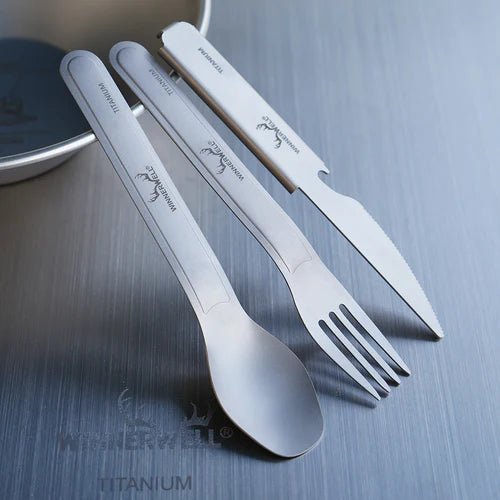 Winnerwell Titanium Cutlery Set mit Löffel, Gabel und Messer schräg an eine Schale gelehnt auf dem Tisch