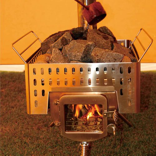 Winnerwell Woodlander Sauna Stove mit Saunasteinen im Korb und Feuer hinter dem Sichtfenster